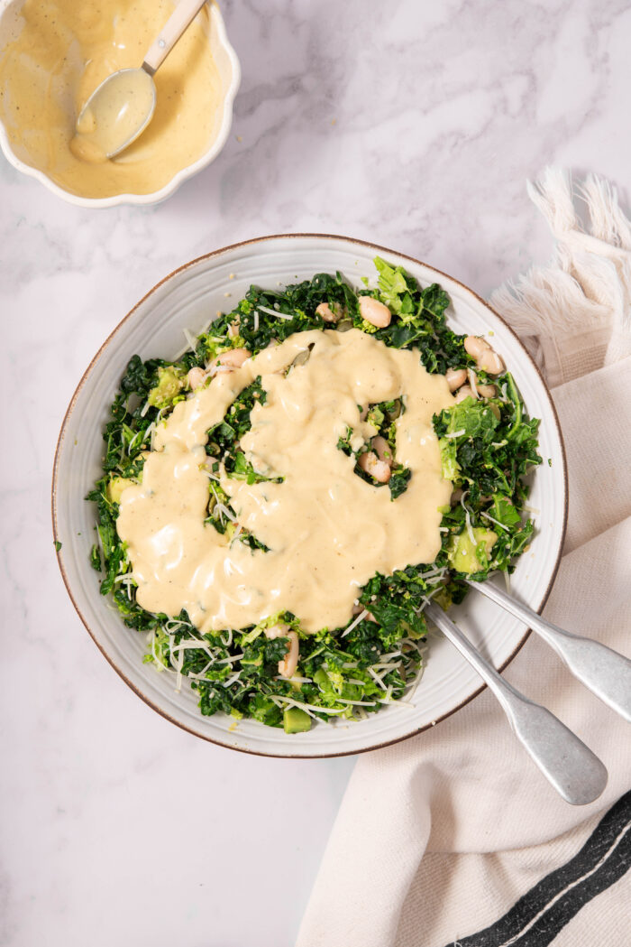 Dressing poured over the veggies and beans to make chopped kale salad.