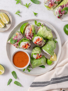 Vegan summer rolls, cut in half and served with almond dip.