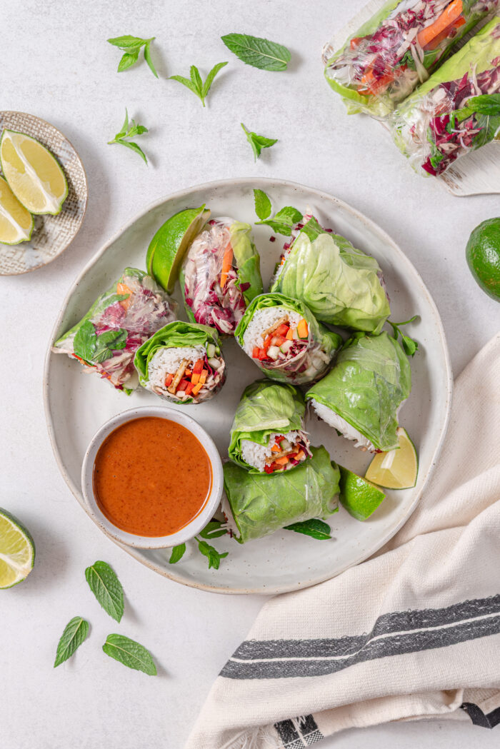 Vegan summer rolls, cut in half and served with almond dip.