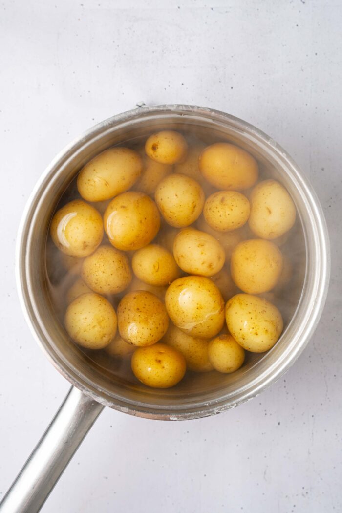 Mini potatoes submerged in water, ready to cook.