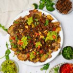 A platter of smashed potato nachos served with black beans, and any of your favorite toppings.
